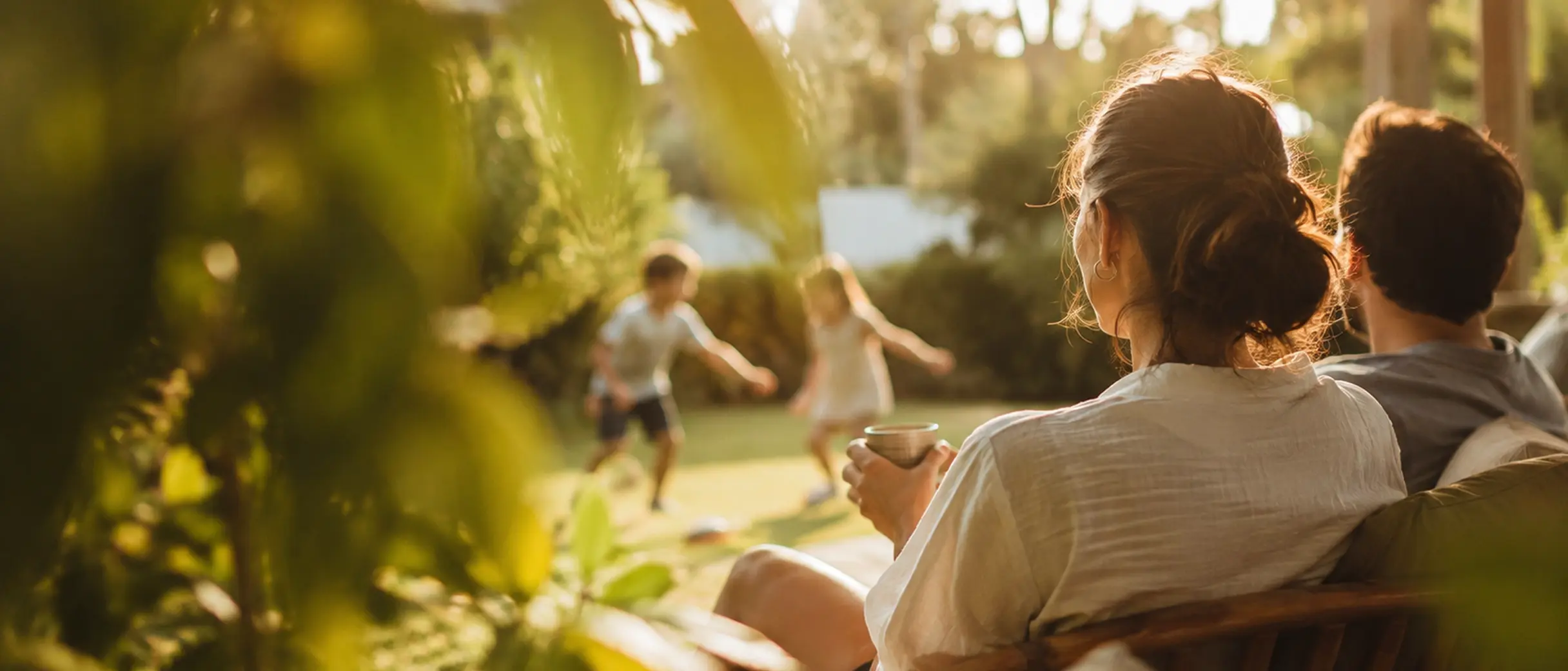 Família reunida no jardim do Monarca ao fim da tarde, com crianças brincando no gramado